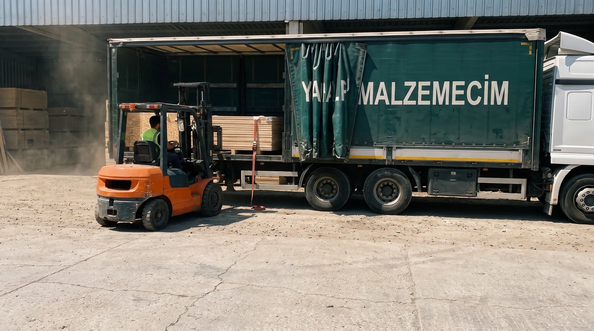 Markalı tırın yanında ahşap levha yükleyen forklift